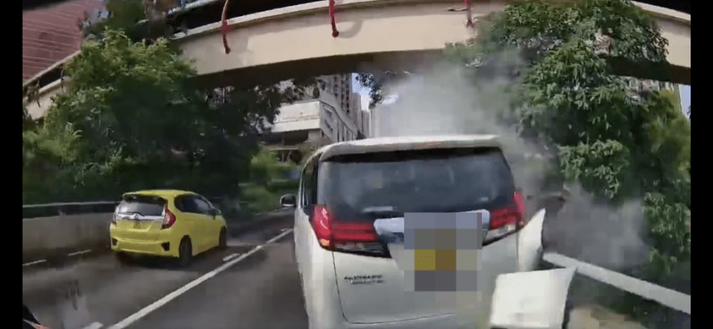 右邊車身在繼續行駛下與石壆猛烈磨擦，冒出白煙。