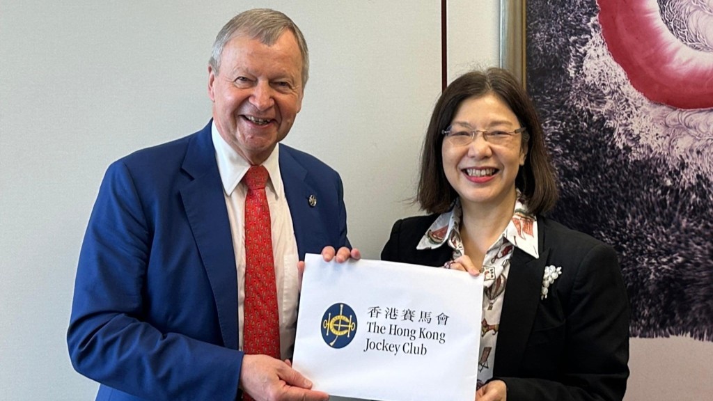 香港賽馬會行政總裁應家柏（左）向政制及內地事務局局長謝小華（右）提交「香港首個五年規劃」建議書。
