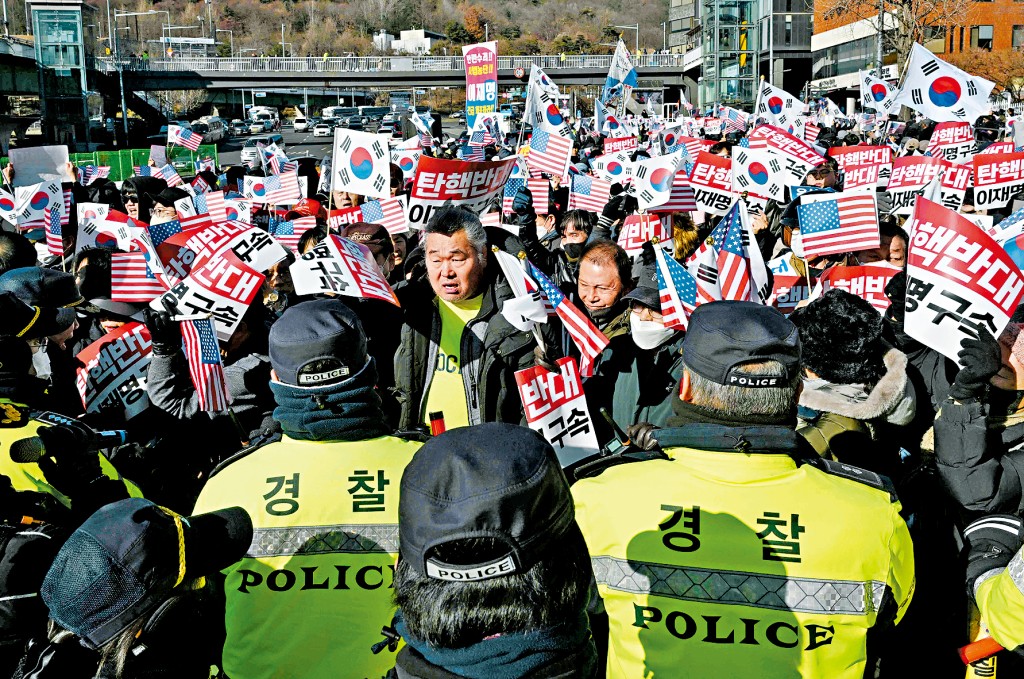 支持總統尹錫悅的民眾周二在首爾總統府外集會，警察在場監視。