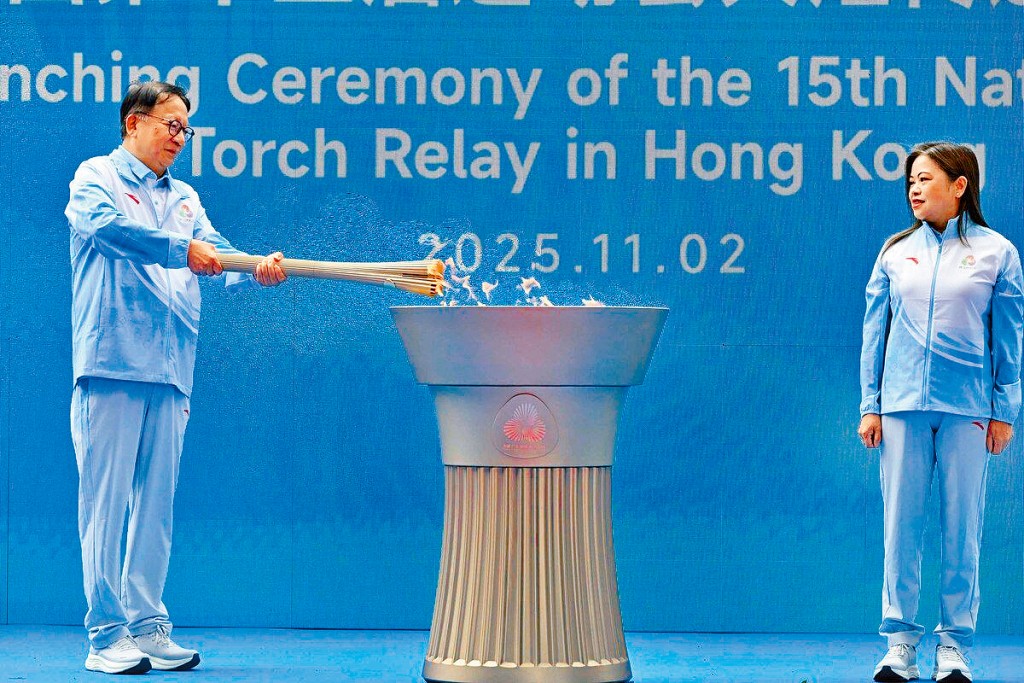 署理行政長官陳國基燃點火炬，右為文化體育及旅遊局局長羅淑佩。