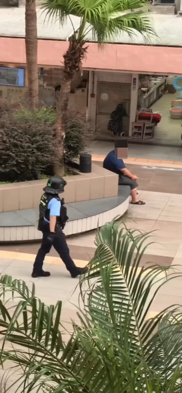 男子手持菜刀坐在竹園南邨的平台。網上片段截圖 男子手持菜刀坐在竹園南邨的平台。網上片段截圖