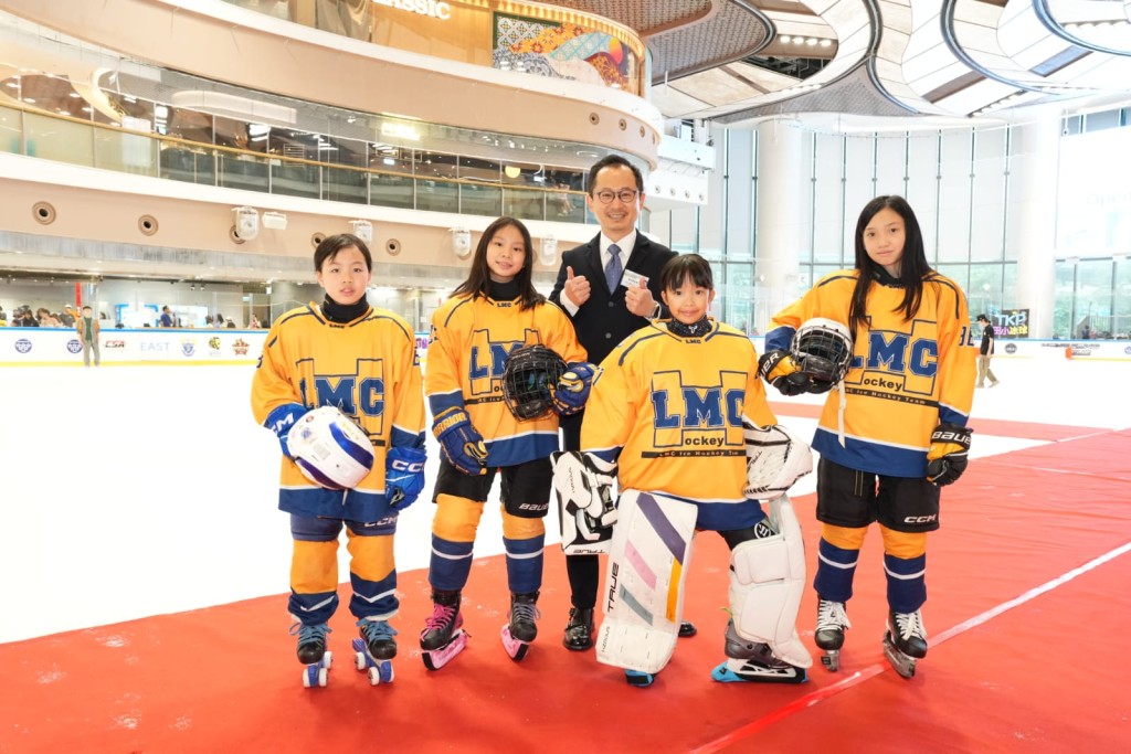 香港冰球訓練學校主席胡文新跟保良局林文燦英文小學的女球員合照。公關提供
