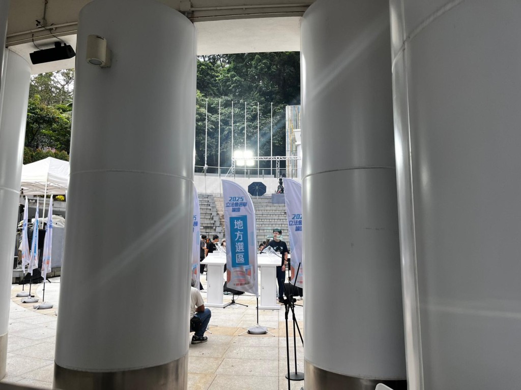 有工作人員在香港公園奧林匹克廣場佈置場地,當中有地區直選字眼的旗幟。李健威攝 有工作人員在香港公園奧林匹克廣場佈置場地,當中有地區直選字眼的旗幟。李健威攝