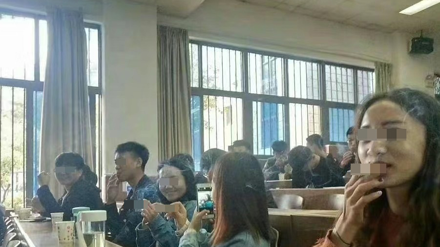 网传河南农业大学烟草学院多名学生疑似在教室内吸烟。 微博图