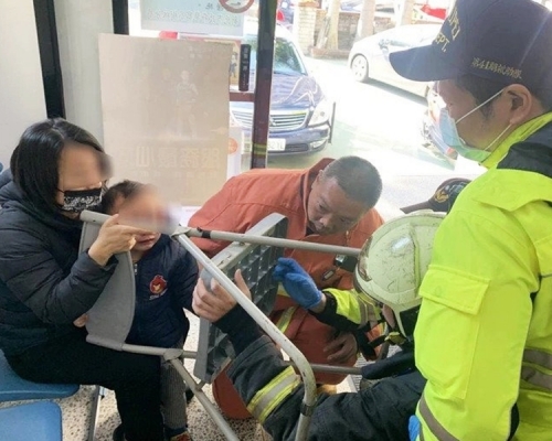 消防員用特殊工具切割塑膠椅,幫助男童脫困。網圖