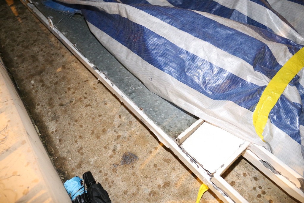 倒塌的铁闸约3米高，1.5米阔，出事后已被移至大闸铁门的后方，以蓝白条帆布盖好。李家杰摄
