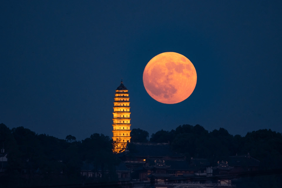 2024年8月19日晚，四川省眉山市東坡區，一輪金黃圓月穿越大旺寺白塔，非常壯觀。 澎湃新聞