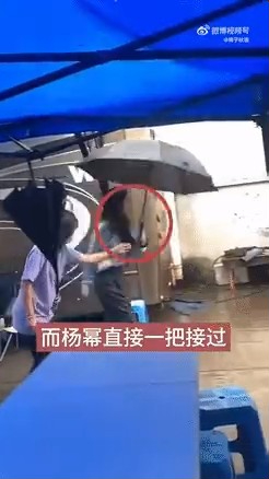 楊冪在助手手上接過雨傘。