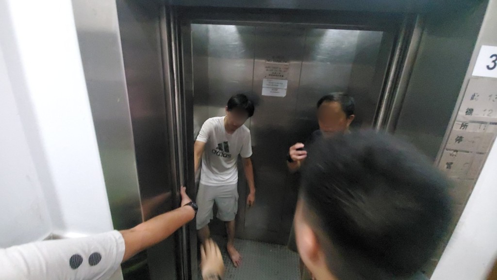其间白衫青年一度拟乘搭电梯上楼。杨伟亨摄