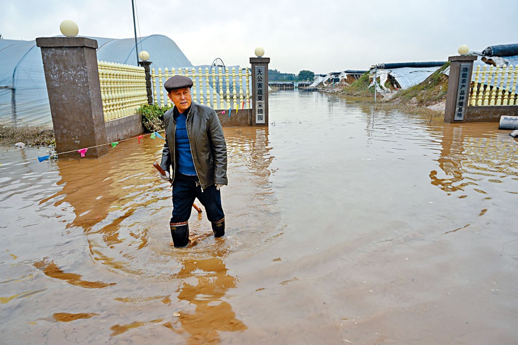 ■山西省介休市義棠鎮北村，蔬菜水果大棚被淹後，村民開展自救。中新社