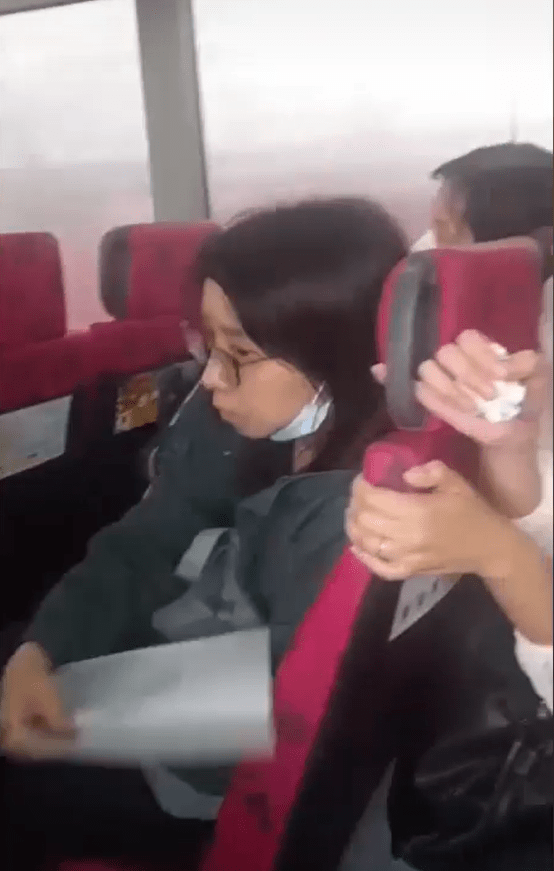 一名女乘客手持書簿替婆婆撥涼。fb:車cam L（香港群組）