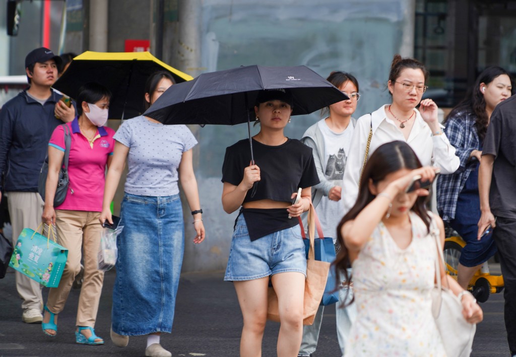 鄭州市民在高溫天氣中出行。中新社