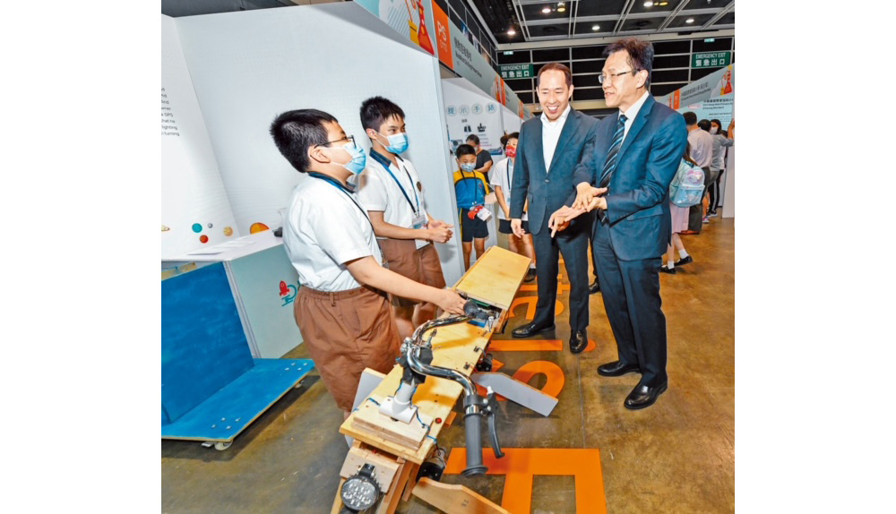 創新科技及工業局局長孫東（右一）及香港創新基金主席黃永光（右二）十分欣賞學生的創意發明。