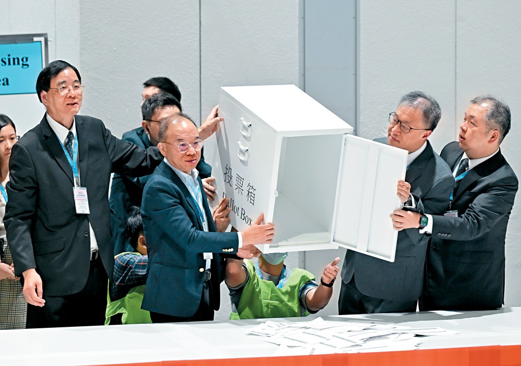 曾國衞和陸啟康等人倒出票箱中的選票。