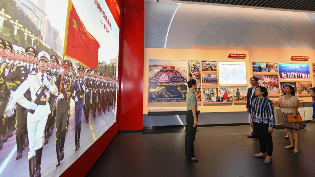 麥美娟(左二)等參觀駐港部隊展覽中心,閱覽中心展板內容。政府新聞處