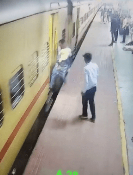 印度大妈右脚而踏上火车梯间。