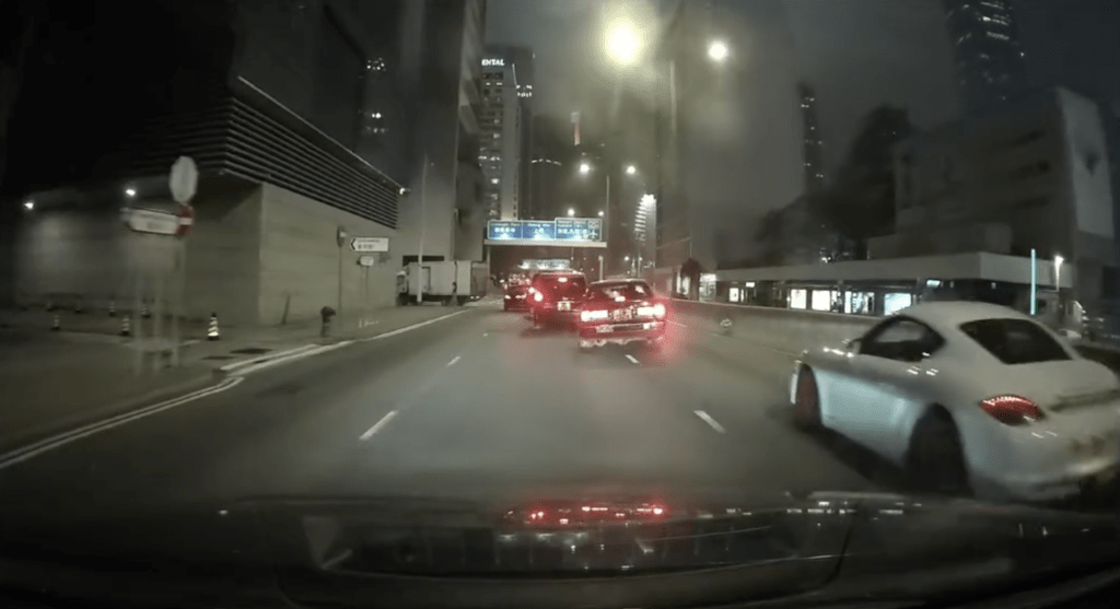 一輛的士疑打左燈切向左線期間,突然再切回右線,尾隨的保時捷收掣不及導致意外。FB車cam L(香港群組)影片截圖 一輛的士疑打左燈切向左線期間,突然再切回右線,尾隨的保時捷收掣不及導致意外。FB車cam L(香港群組)影片截圖