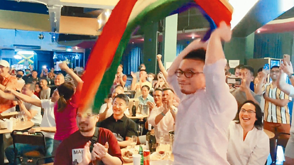 一名男子周日揮舞彩虹旗,慶祝新加坡廢除男男性行為列刑事罪行的法例。