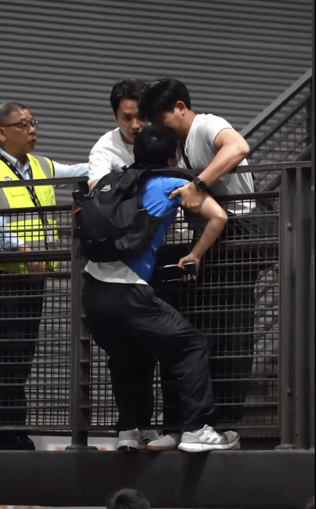 两名怀疑便衣警员将男事主捉实，以防堕下。Threads @ 3533pang5251影片截图