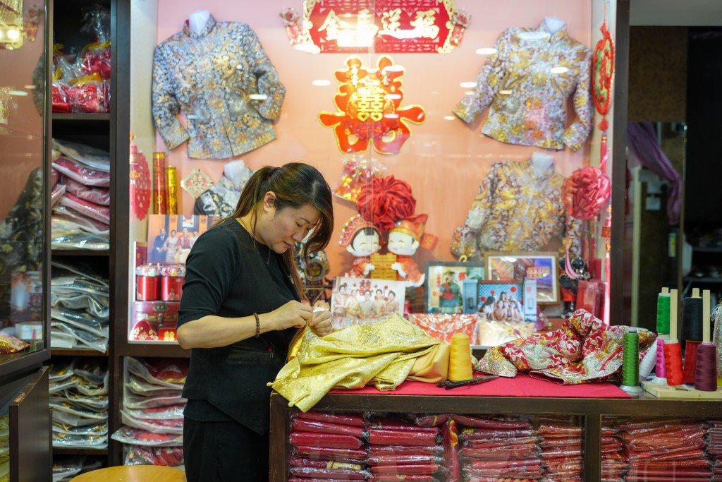冠南華的裙褂採用跨境分工模式,刺繡工序在蘇州完成,後期製作則全部在香港進行。 冠南華的裙褂採用跨境分工模式,刺繡工序在蘇州完成,後期製作則全部在香港進行。