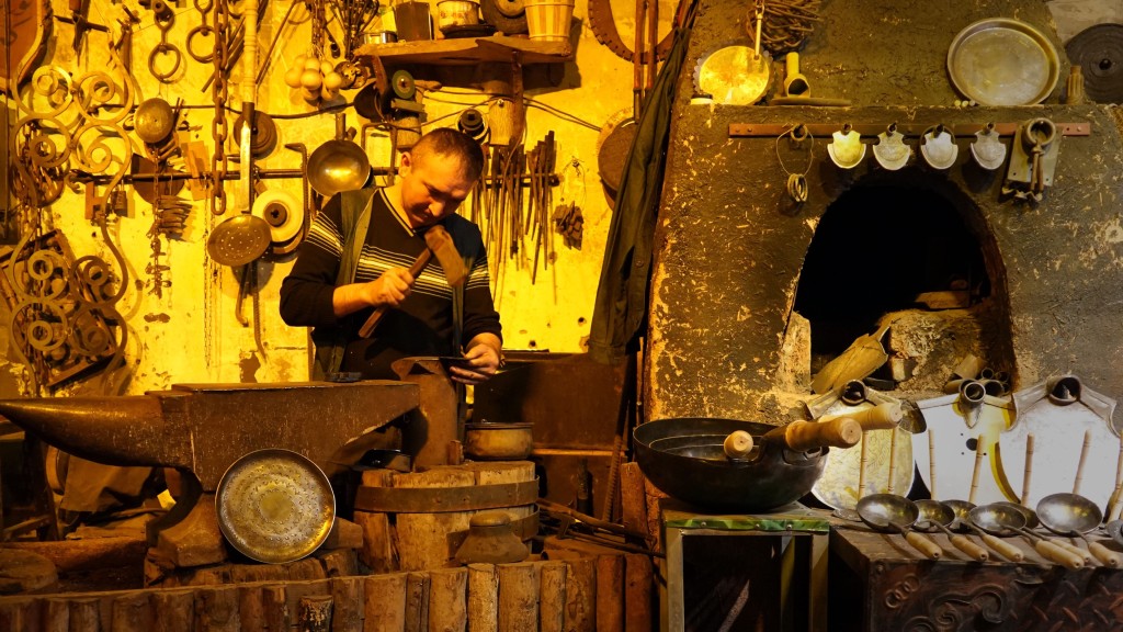 在新疆喀什古城景区铁业公社内，手艺人在制作铁器。  新华社