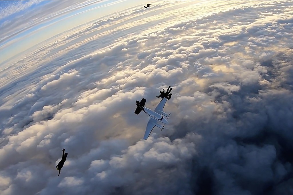 俯冲的飞机在跳伞队员身边掠过,十分惊险。互联网图片