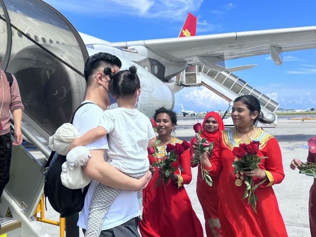 旅游部门向中国旅客送上玫瑰花。