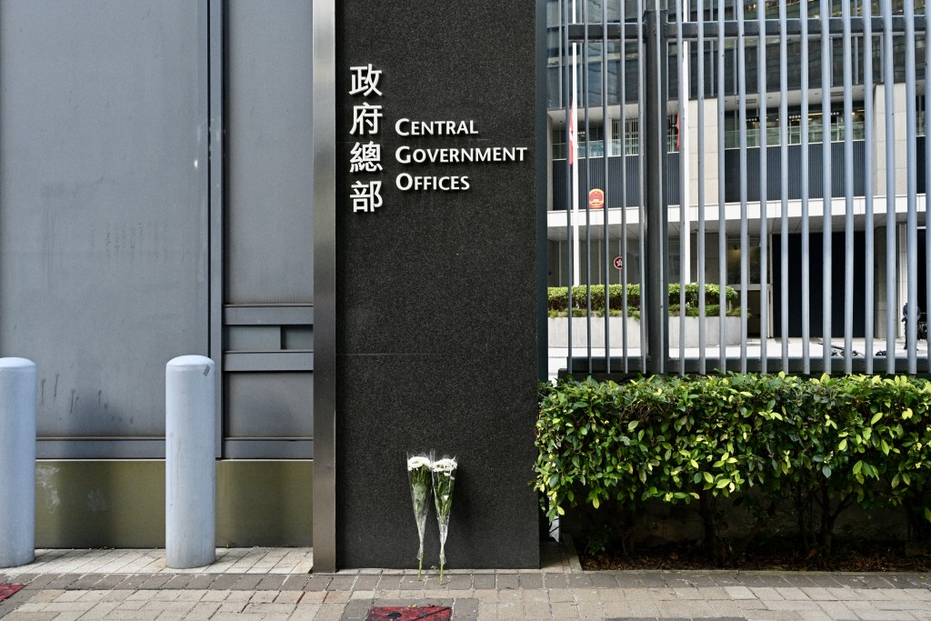 有市民靜悄悄地放下兩束白色花於政總門外悼念。 有市民靜悄悄地放下兩束白色花於政總門外悼念。