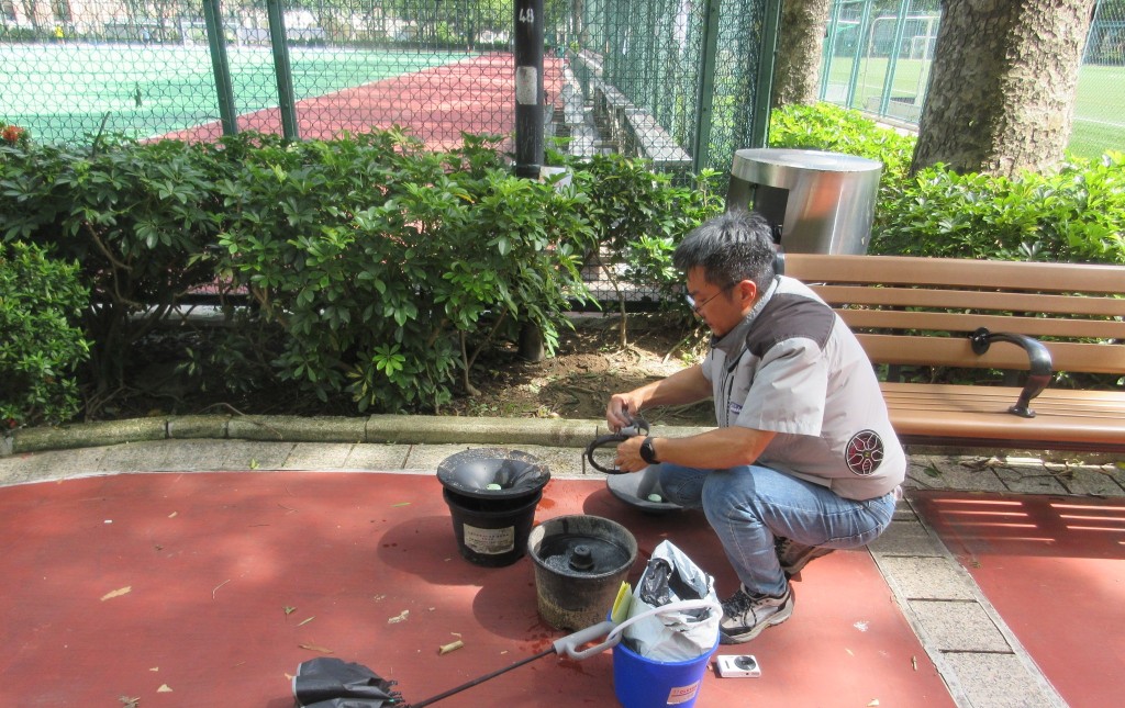 工作人員在康文署轄下公園放置蚊子誘捕器。