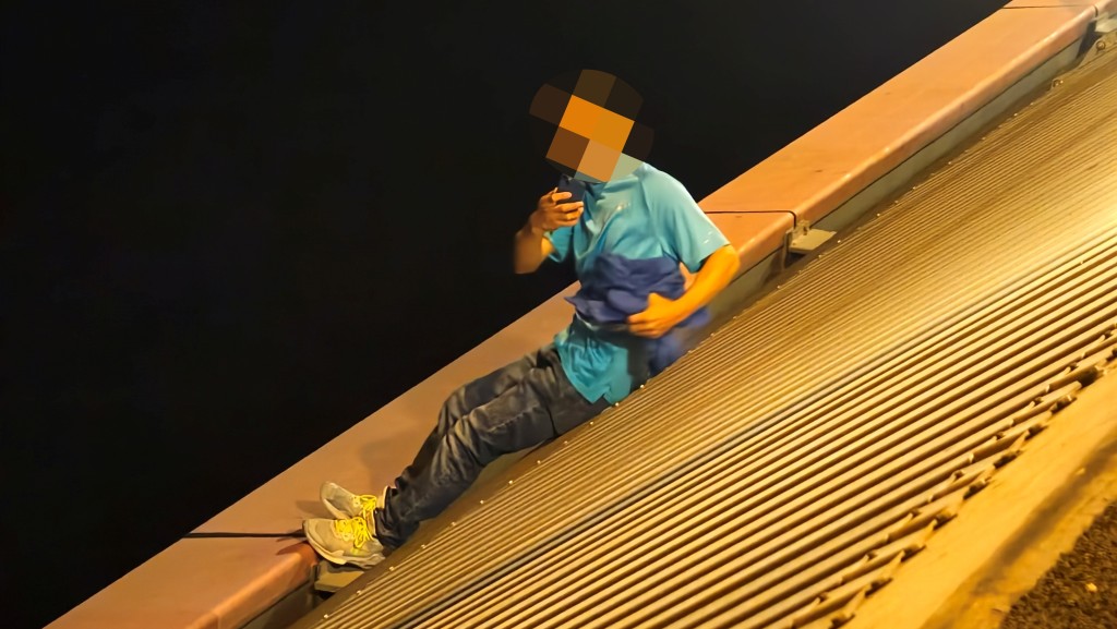 藍衫男子與救援人員對峙,舉手機四處拍攝。 藍衫男子與救援人員對峙,舉手機四處拍攝。