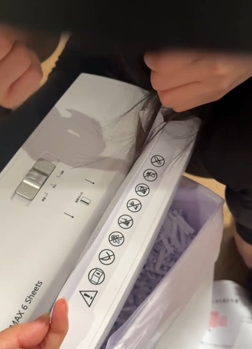 片中見到戴鴨舌帽的長髮女正蹲在碎紙機 旁,一撮頭髮被碎紙機「食」著,連同正 在切碎的文件一同夾在入紙口;為保秀髮 ,長髮女正關掉碎紙機。Threads截圖 片中見到戴鴨舌帽的長髮女正蹲在碎紙機 旁,一撮頭髮被碎紙機「食」著,連同正 在切碎的文件一同夾在入紙口;為保秀髮 ,長髮女正關掉碎紙機。Threads截圖