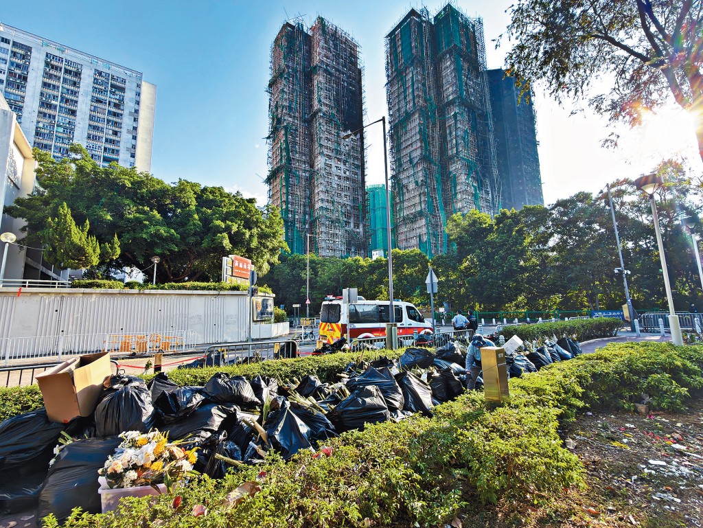 被辟作「花坛」及「留言亭」悼念罹难者的广福休憩处昨凌晨清场，摆放于该处的花卉被暂放一旁以待清理。