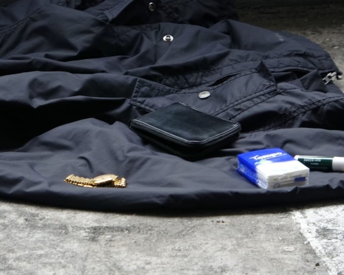 警方在停車場檢獲死者的財物。