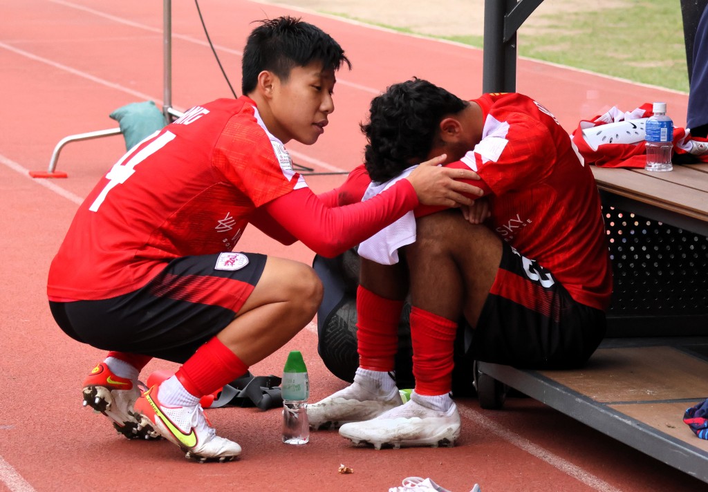香港U23的宏愷志（右）因犯錯令球隊一再失波，難過掩著臉，要隊友安慰。（陸永鴻攝）