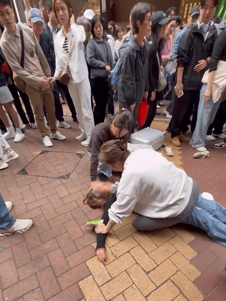 一名本地女子压坐在外籍妇身上，当街斥责外籍妇。