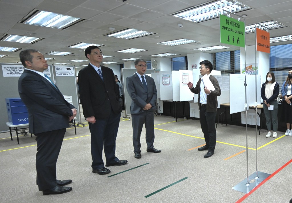 陆启康（左三）听取选举事务处工作人员简介一般队伍和特别队伍的运作。政府新闻处图片