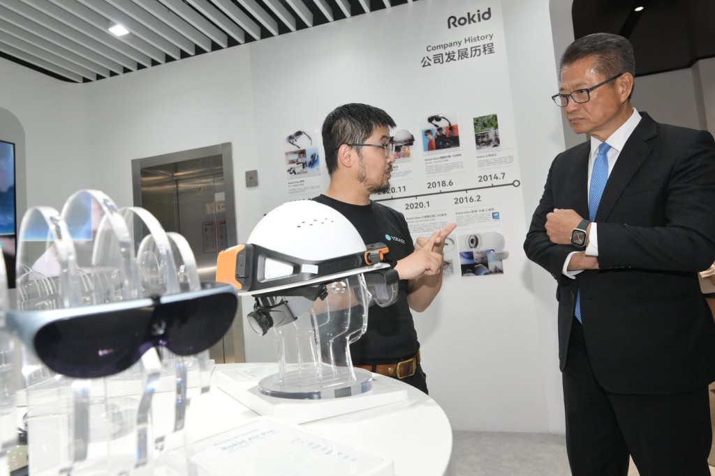 陳茂波（右）到訪當地科創企業，向負責人了解最新的技術研發成果和發展計劃。政府新聞處