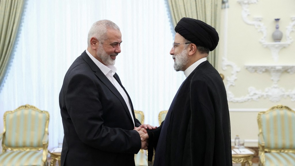 伊朗總統萊希與哈馬斯領袖哈尼亞握手。 路透社