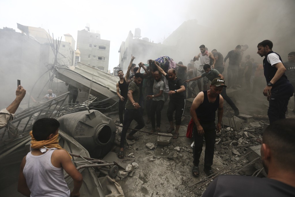 以軍空襲加沙，搜救人員在瓦礫堆中抬出屍體。美聯社