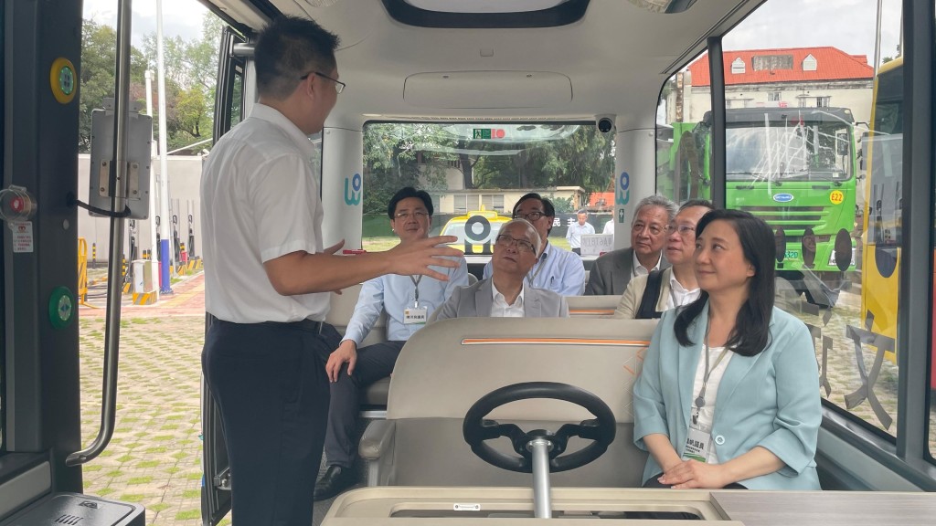谢展寰（第二排右二）和立法会环境事务委员会访问团听取负责人讲解产业园内无人驾驶车辆。政府新闻处