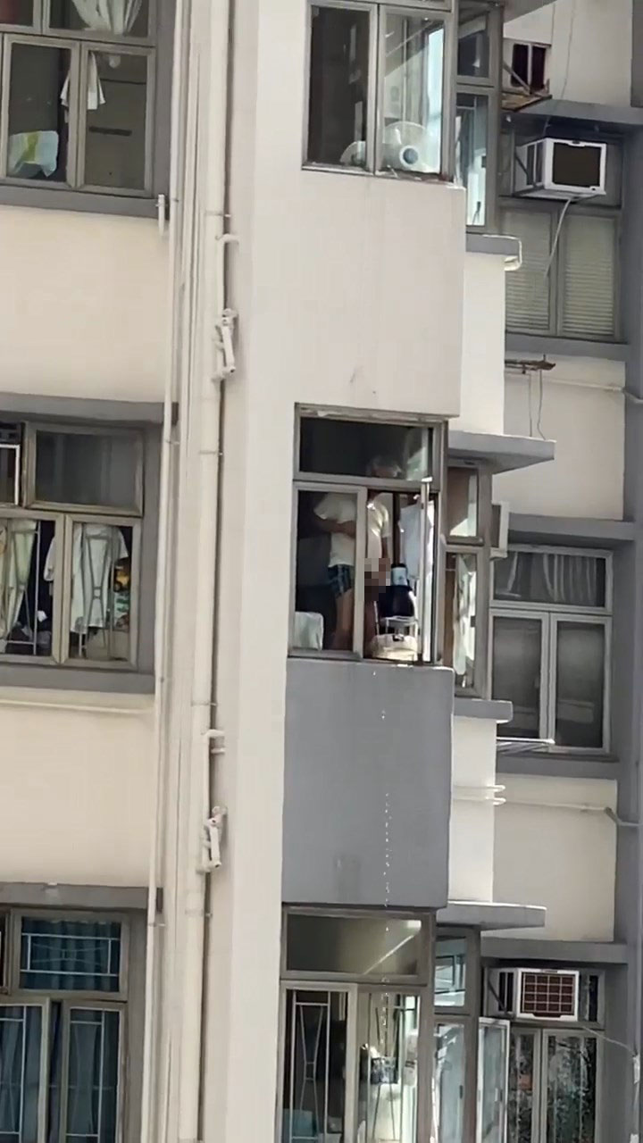 一名男子站在窗台，向街外小便。網上片段截圖