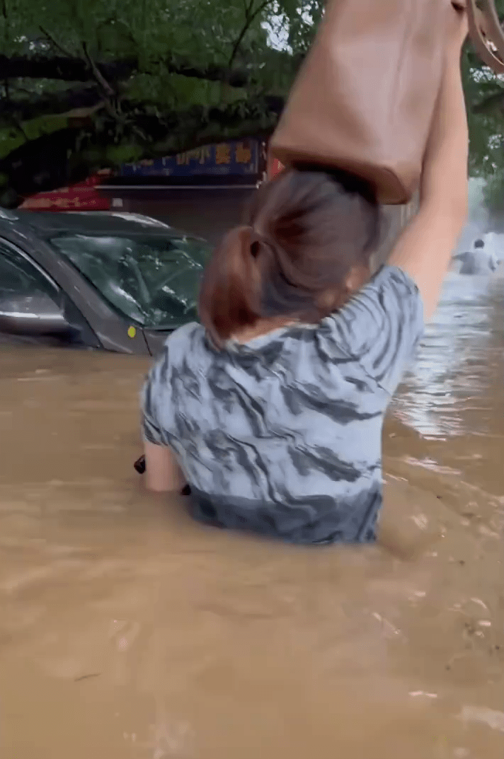 桂林市城区出现洪水倒灌，水浸严重，市民举步艰难涉水而行。