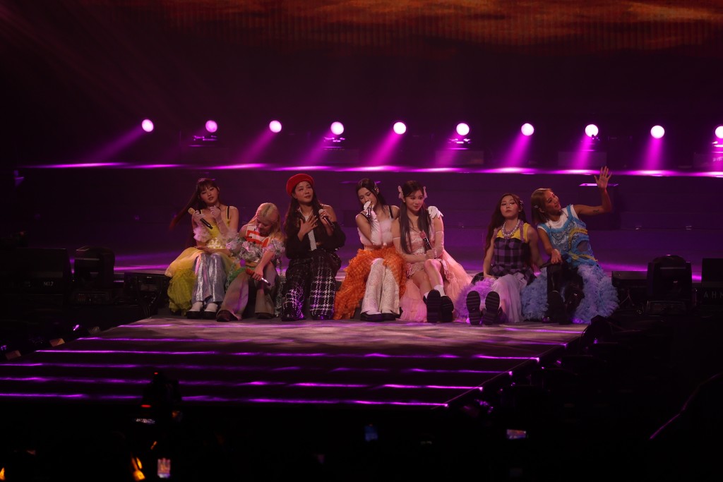 七女合體唱慢歌《Never-never Land》齊齊坐在台邊，着超短裙的Candy驚走光不斷用手按實裙邊。