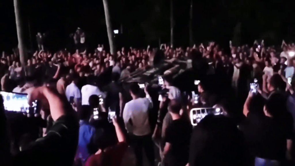 網片顯示,現場一群人破壞及推翻一輛汽車。 網片顯示,現場一群人破壞及推翻一輛汽車。