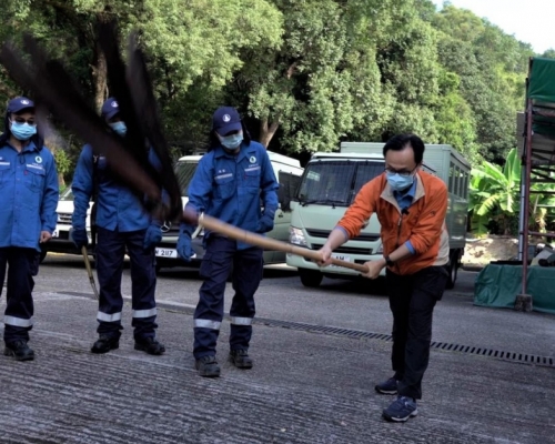 聶德權局長在隊員指導下，學習「打火」。