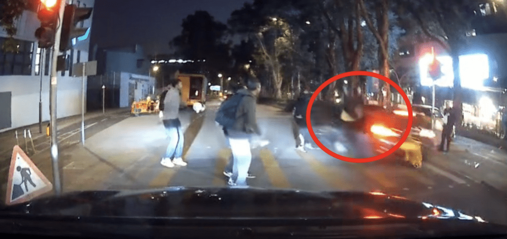 当自行车行至接近道路中央行人等候处时，一辆私家车突然高速冲出，将其猛力撞飞。