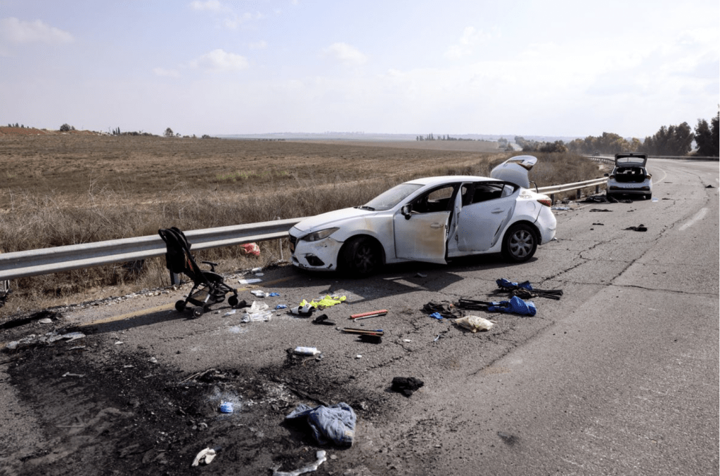 在以色列一城镇的平民汽车遭袭击后，只剩下物件散落路上。路透社