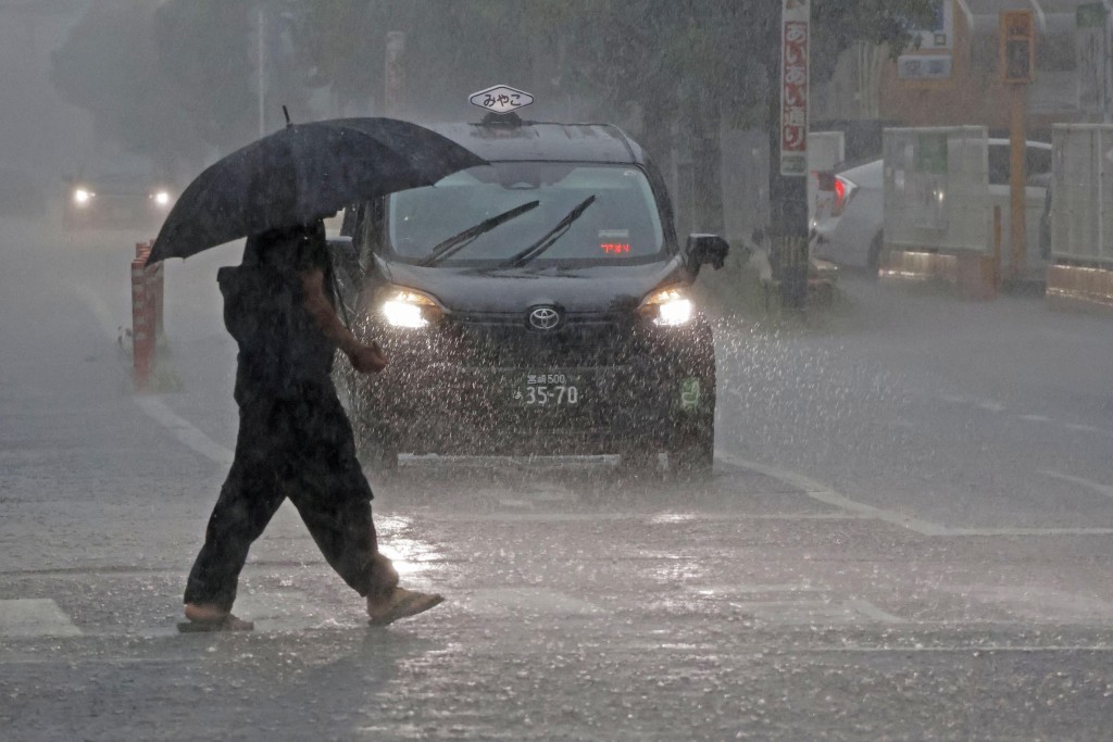 鹿兒島市民冒風雨外出。路透社