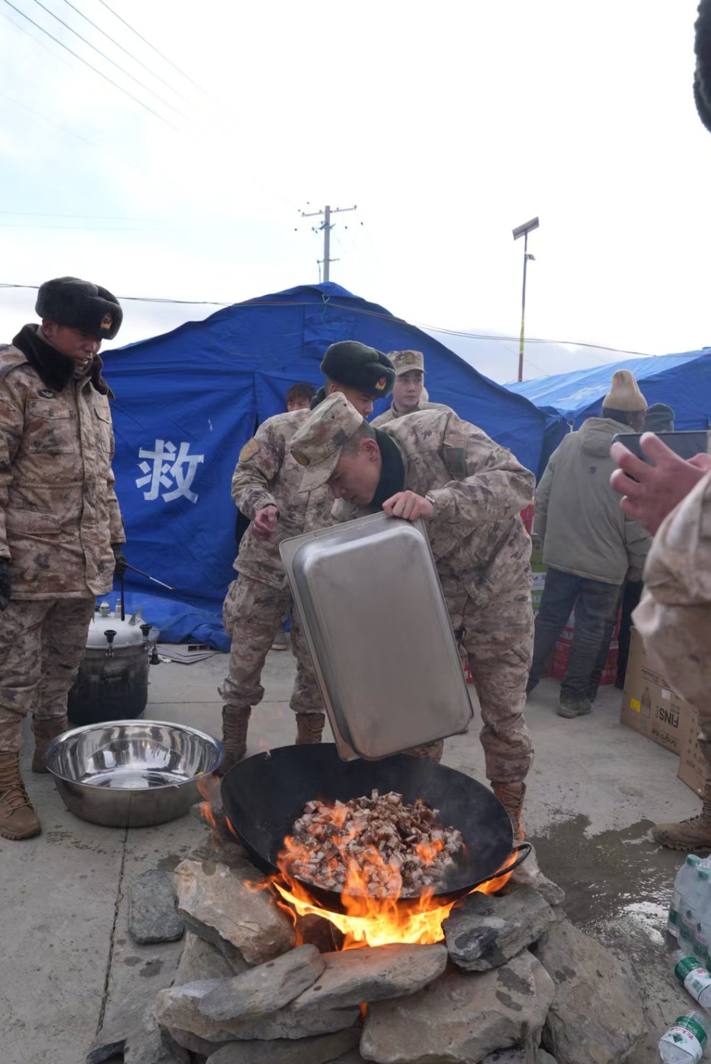  1月7日，在定日縣長所鄉古榮村，救援人員在準備晚飯。 新華社