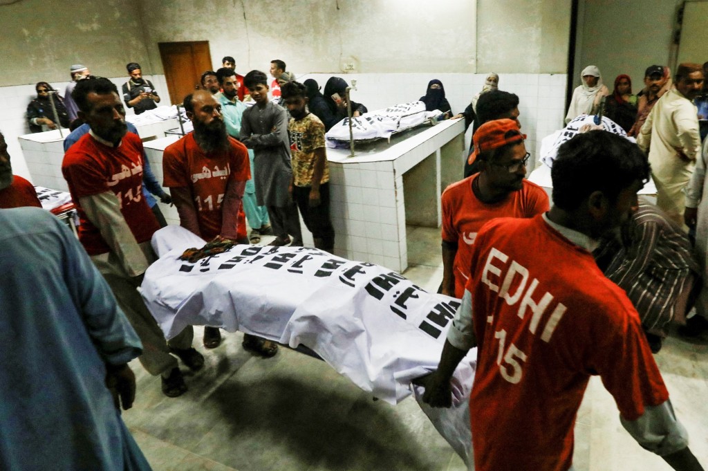 卡拉奇搶食物人踩人事故死者遺體被抬進太平間。 路透社